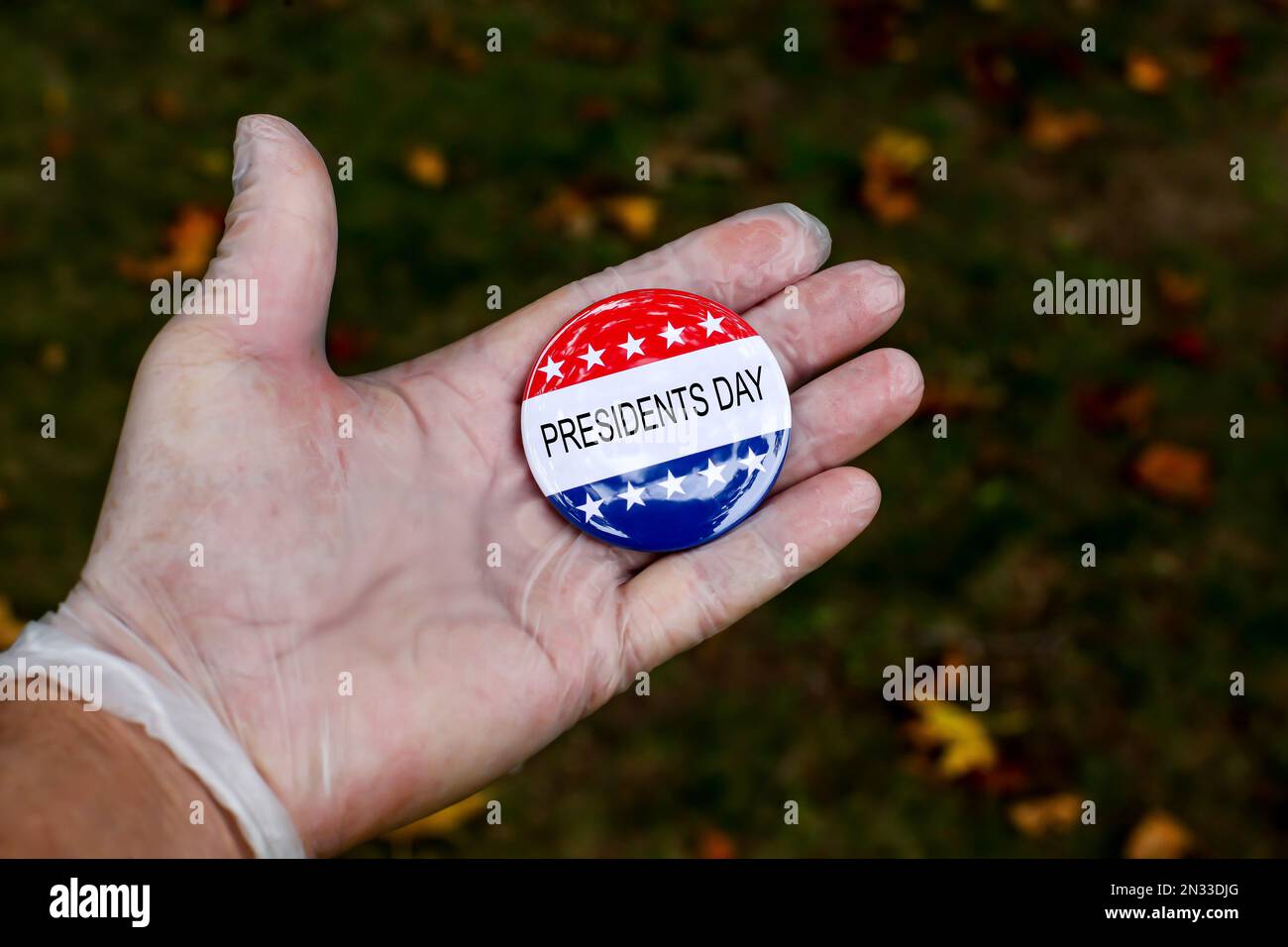 Hand mit Schutzhandschuh, die die Wählnadel-Schaltfläche mit dem Text Presidents Day zeigt Stockfoto