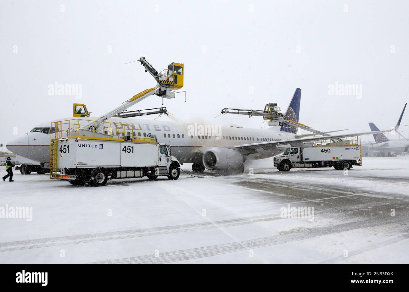 Crews work to deice a plane at O'Hare International Airport on Sunday