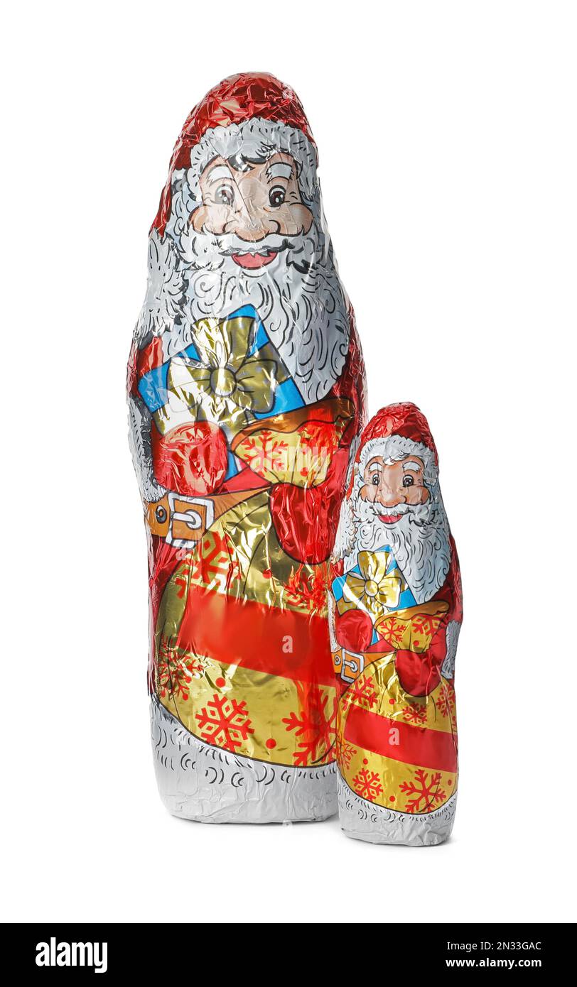 Weihnachtsmann-Figuren in Folienverpackungen auf weißem Hintergrund Stockfoto