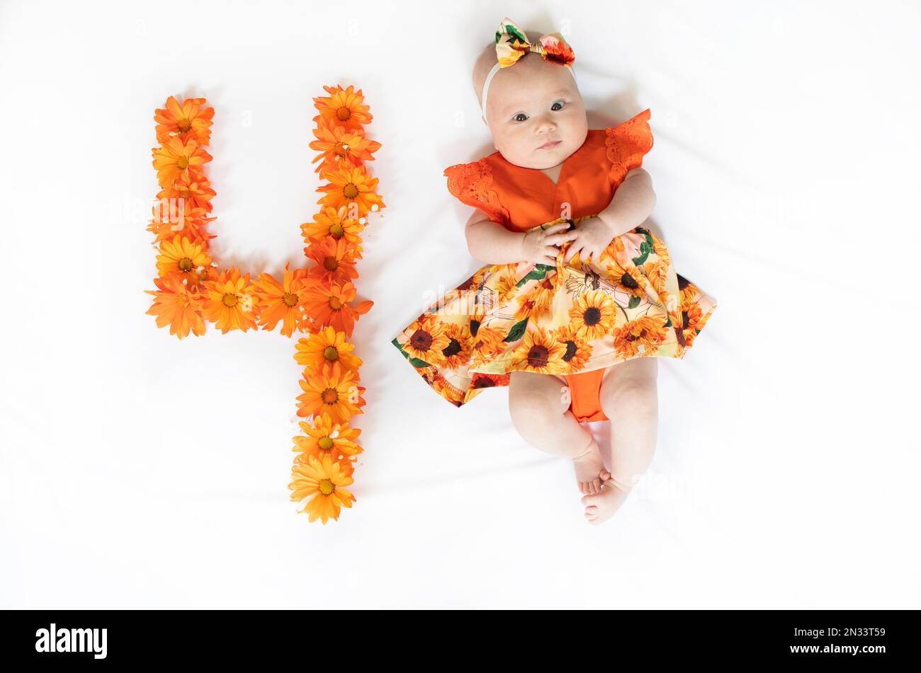 Süßes, 4 Monate altes Mädchen in einem Kleid. 4 Monate altes Baby Stockfoto