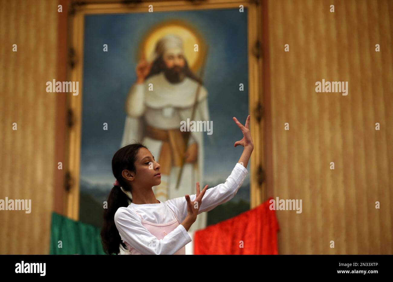 An Iranian Zoroastrian girl dances in front of a portrait of Prophet