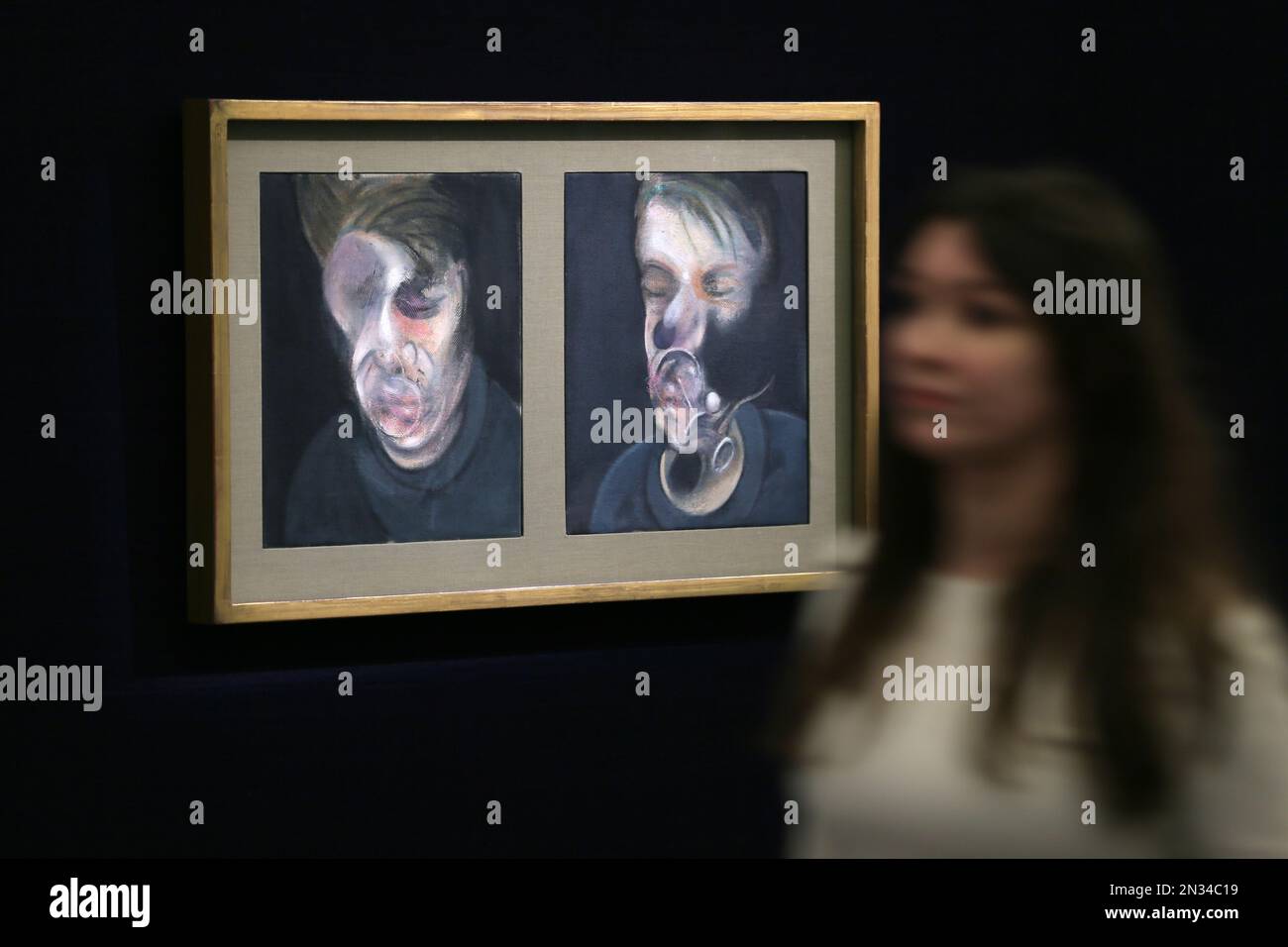 A member of Sotheby's staff poses for a picture with ''Two Studies for a Self-Portrait' by Francis Bacon during a preview of their upcoming Impressionist and Modern, Surrealist and Contemporary Art sale, at the auction house in London, England, Wednesday, Jan. 28, 2015. The collection of paintings and sculptures, with an estimated total value of 233 million pounds ($354 million), is due to go under the hammer on Feb. 3 and Feb. 10. (AP Photo/Tim Ireland) Stockfoto