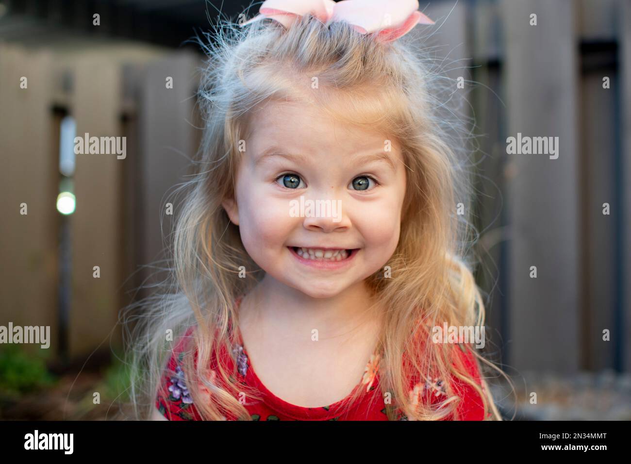 Süßes weißes kleines Mädchen mit blauen Augen, die in die Kamera lächeln. Stockfoto