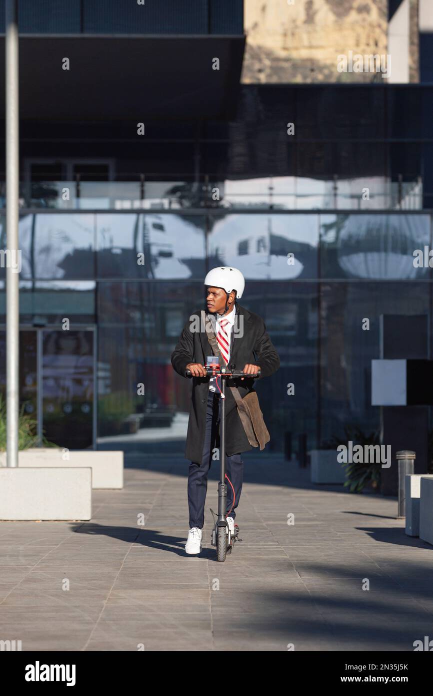 Ein Lateiner, der mit einem elektrischen Roller in der Stadt fährt Stockfoto