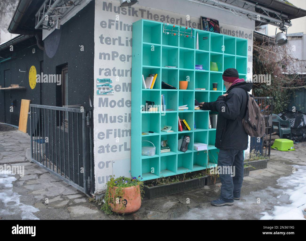 Villach, Osterreich - Dezember 24. 2022. Ein Passant hält an, um sich Bücher und andere Gegenstände anzusehen, die an einer Buchbörse im Stadtzentrum in Villach, Kärnten, zurückgelassen wurden Stockfoto