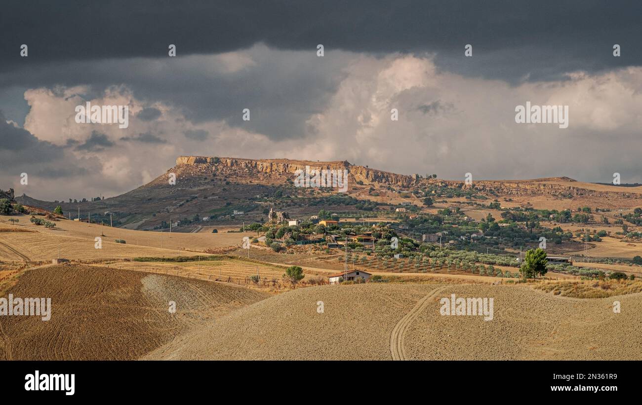 Landwirtschaftlich genutzte Fläche im Landesinneren Südwestsiziliens an einem bewölkten und sonnigen Nachmittag; Provinz Agrigento, Italien Stockfoto