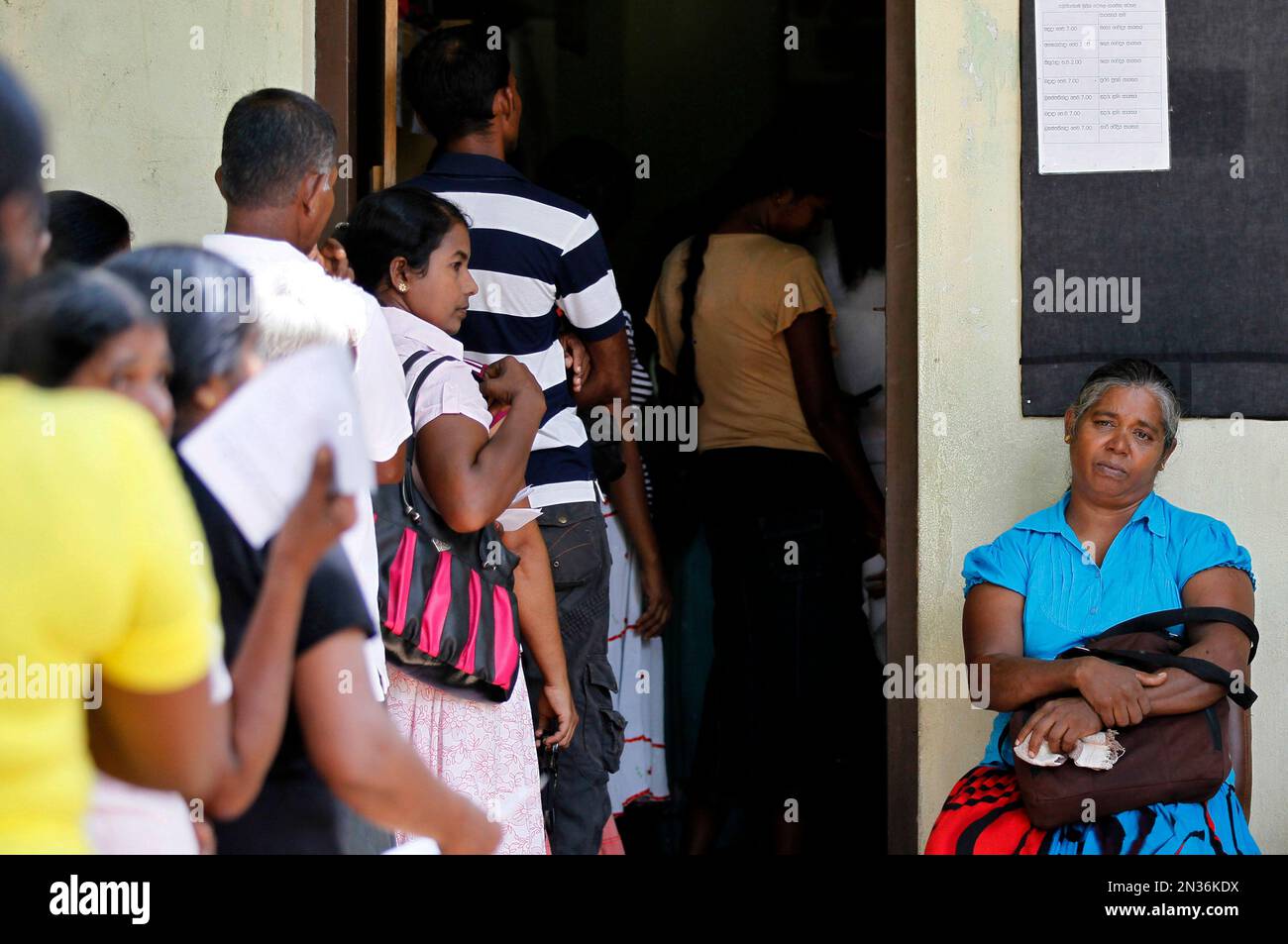 In this July 25, 2014, photo, a Sri Lankan woman waits her turn to meet
