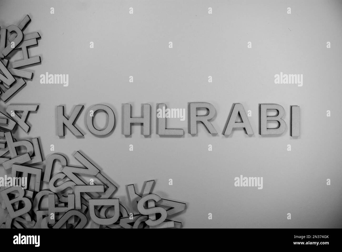 KOHLRABI in hölzernen englischen Wörtern, Großbuchstaben, die aus einem Stapel schwarz-weißer Buchstaben herausfließen Stockfoto
