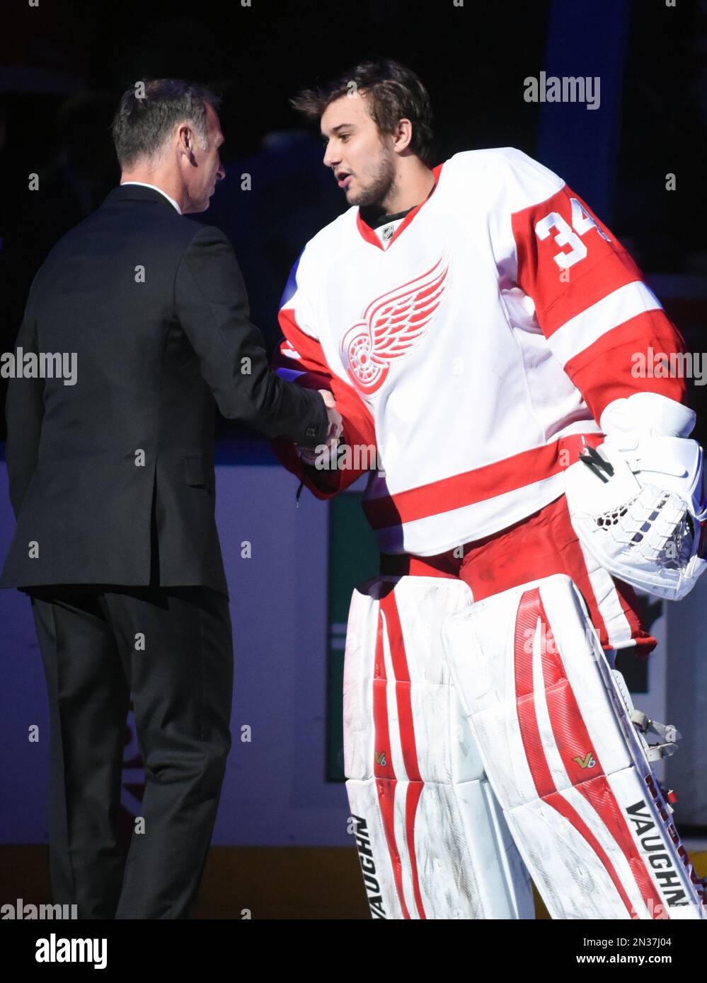 Buffalo Sabres alumni goaltender Dominik Hasek, of the Czech Republic, is greeted by Detroit Red Wings goaltender Petr Mrazek (34), also of the Czech Republic, after a pre-game ceremony honoring Hasek by retiring his number prior to the start of Detroit Red Wings and Buffalo Sabres NHL hockey game Tuesday, Jan. 13, 2015, in Buffalo, N.Y. (AP Photo/Gary Wiepert) Stockfoto