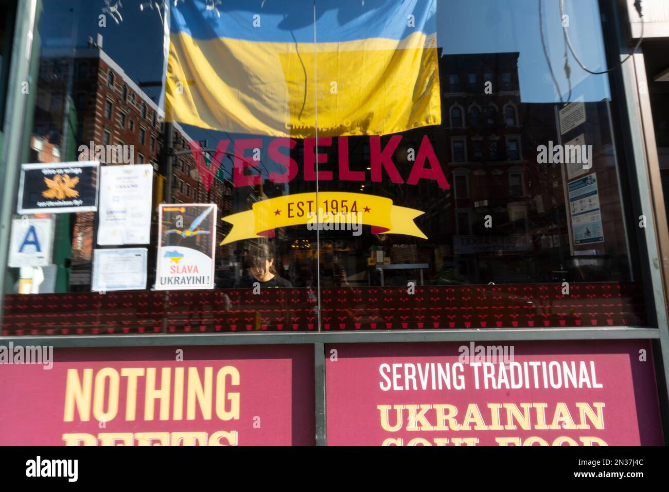 NEW YORK, NEW YORK - MÄRZ 16: Die ukrainische Flagge wird während der russischen Invasion des ukrainischen Restaurants Veselka im East Village an das Fenster gesetzt Stockfoto