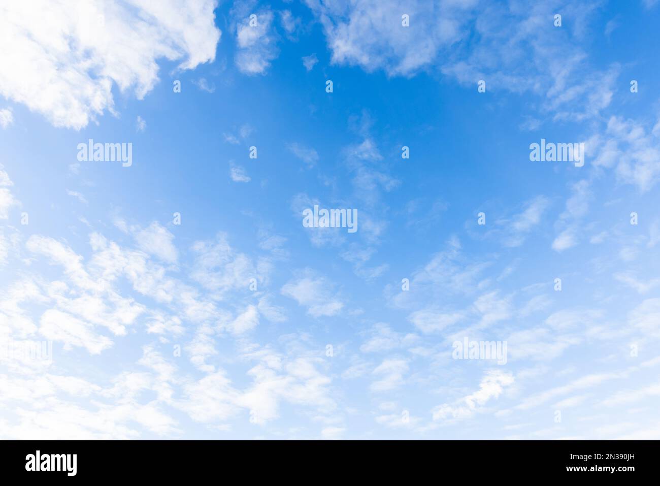 Blauer Himmel mit weißen Altocumulus-Wolken an einem sonnigen Tag, natürliche Fotostruktur im Hintergrund Stockfoto