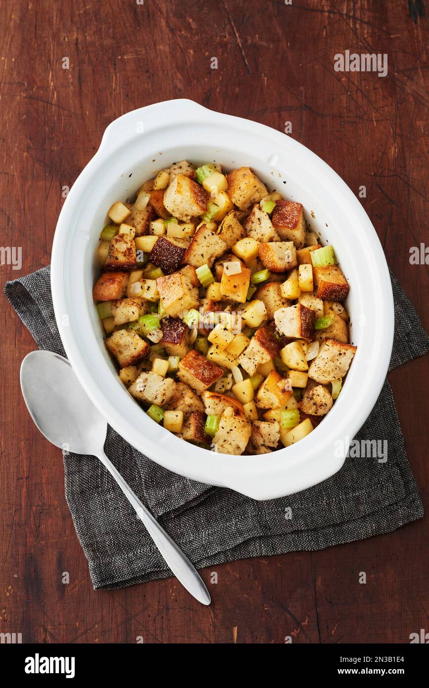 Servierteller mit Brotfüllung und Löffel auf Holzhintergrund Stockfoto