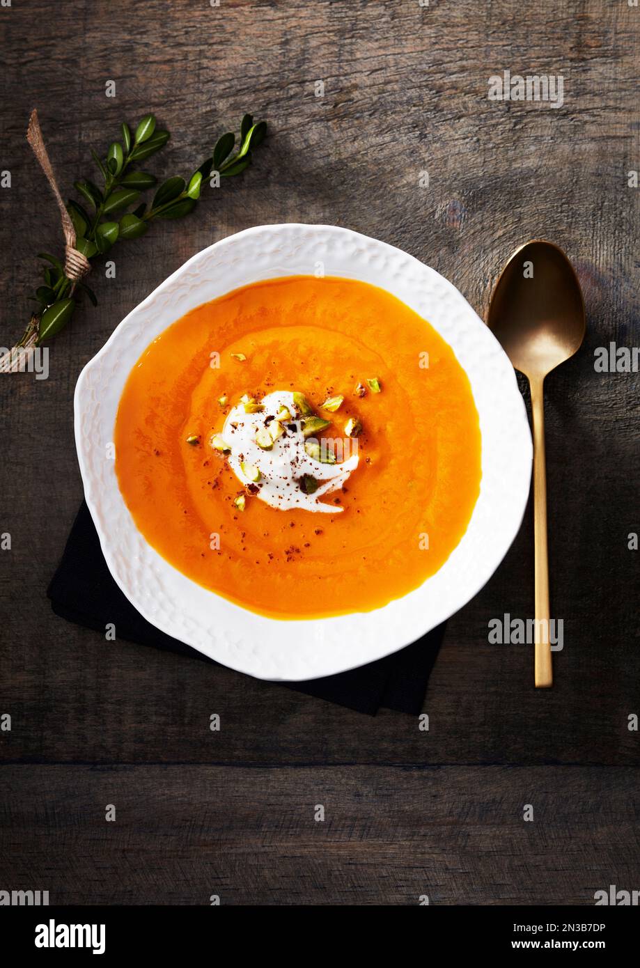 Süßkartoffelsuppe in einer weißen Schüssel mit Sahne Stockfoto