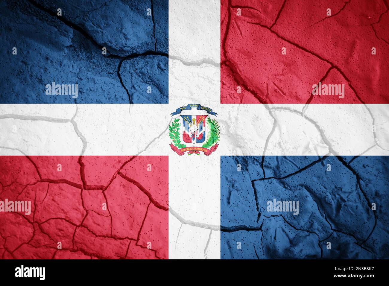 Flagge der Dominikanischen Republik. Symbol für die Dominikanische Republik. Flagge auf dem Hintergrund von trockener, gerissener Erde. Flagge der Dominikanischen Republik mit Dürrekonzept Stockfoto