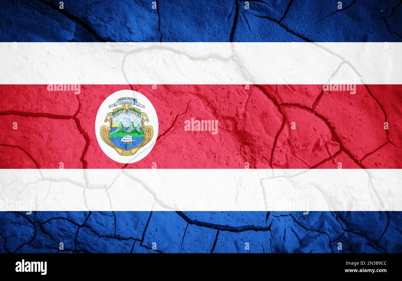 Flagge Costa Ricas. Costa Rica-Symbol. Flagge auf dem Hintergrund von trockener, gerissener Erde. Costa-Rica-Flagge mit Dürrekonzept Stockfoto