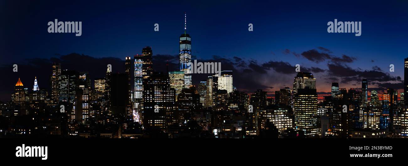 Eine breite Fotografie der Skyline von Downtown New York City kurz nach Sonnenuntergang. Das Foto, das von den Silver Towers auf der Houston Ave gemacht wurde, zeigt den Freedom Tower. Stockfoto