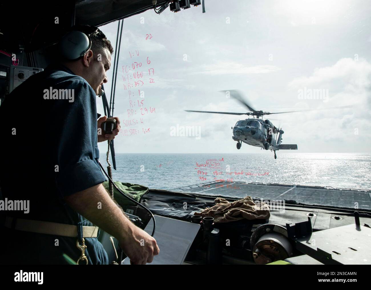 230203-N-HG846-1091 SÜDCHINESISCHES MEER (3. Februar 2023) – leitender Chef des Logistikspezialisten Alfredo Gonzalez aus Villa Clara, Kuba, kommuniziert mit einem MH-60s Seahawk, der den „Blackjacks“ der Helicopter Sea Combat Squadron (HSC) 21 im Flugturm an Bord des Kampfschiffs USS Charittleston der Independence-Variante (LCS 18) zugewiesen wurde. Im Südchinesischen Meer, Februar 3. Charleston, Teil des Destroyer-Geschwaders 7, ist im Rotationseinsatz im US-7.-Flottengebiet tätig, um die Interoperabilität mit Alliierten und Partnern zu verbessern und als einsatzbereite Einsatztruppe zur Unterstützung eines freien und zu dienen Stockfoto