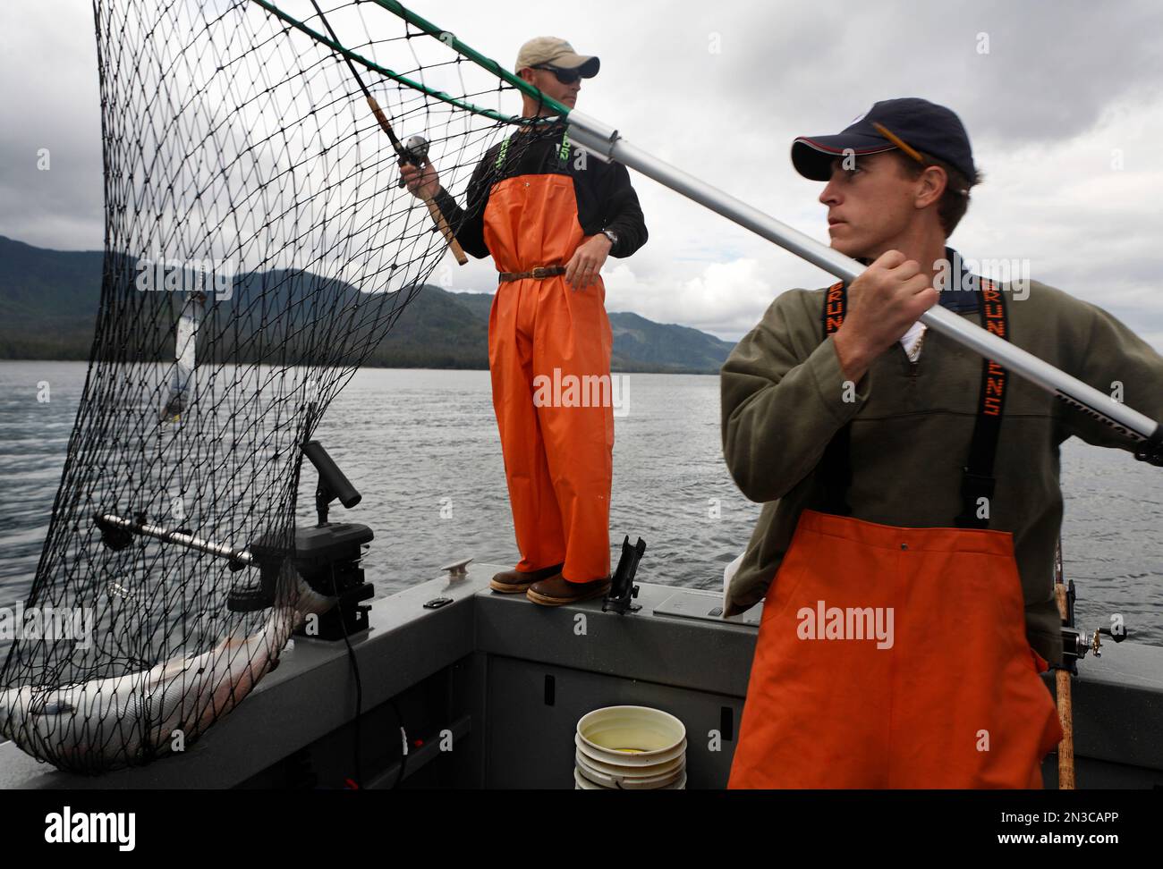 Zwei Fischer fischen einen Lachs in der Nähe von Prince of Wales Island in den unberührten Gewässern von Südost-Alaska; Alaska, Vereinigte Staaten von Amerika Stockfoto
