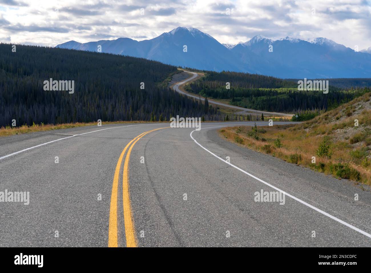 Der Alaska Highway schlängelt sich nach Norden auf dem Weg nach Alaska, wo die Berge des Kluane-Nationalparks in der Ferne zu sehen sind; Yukon, Kanada Stockfoto