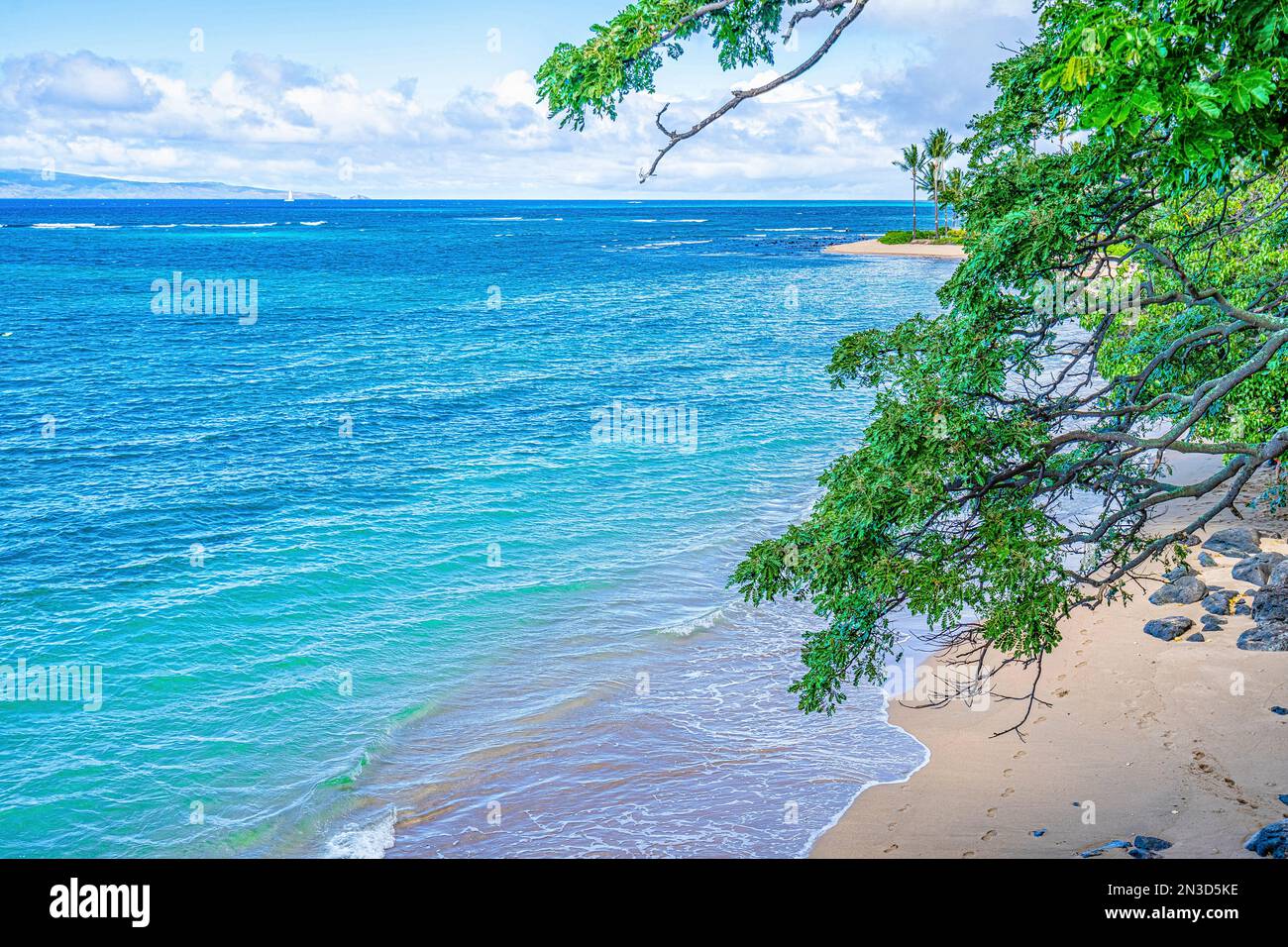 Türkisfarbenes Wasser des Pazifiks, das sanft am Ufer eines abgeschiedenen Strandes in Lahaina, Maui, Hawaii, Vereinigte Staaten von Amerika, schlängelt Stockfoto