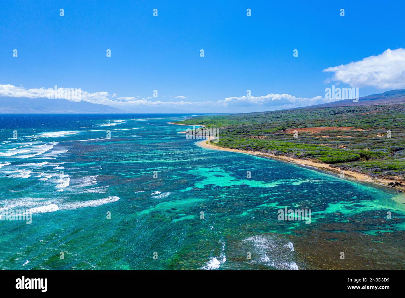 Blick aus der Vogelperspektive auf die Küste von Shipwreck Beach in Lanai mit türkisfarbenem Wasser und Meereswellen, die in die Küste hineinrollen Stockfoto