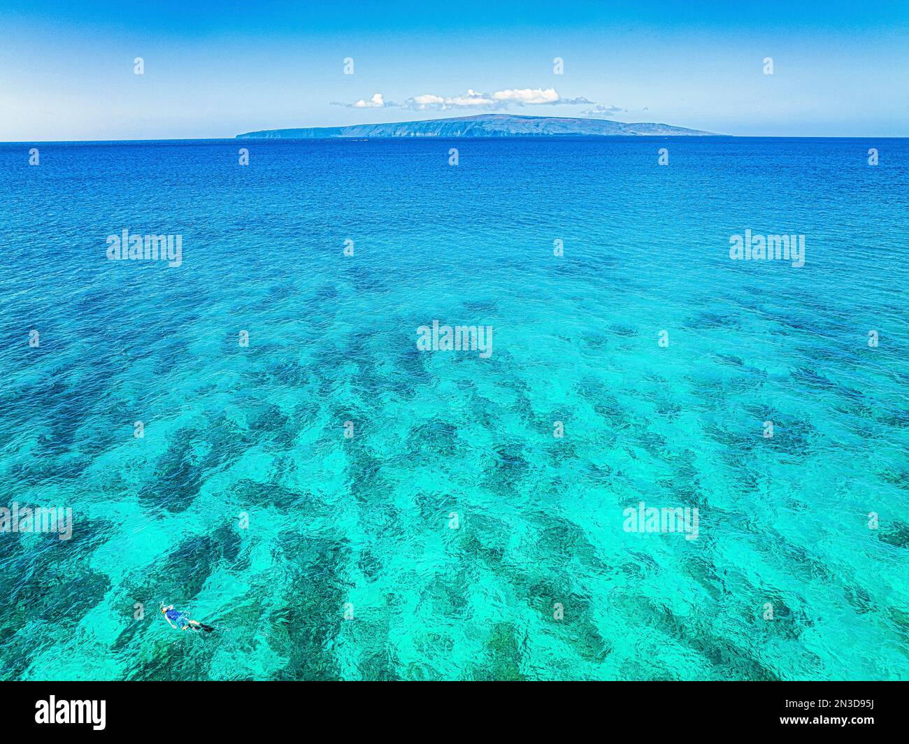 Eine einsame Person schnorchelt im unberührten, pulsierenden türkisfarbenen Wasser des Pazifiks am Ufer von Big Beach in Makena Stockfoto