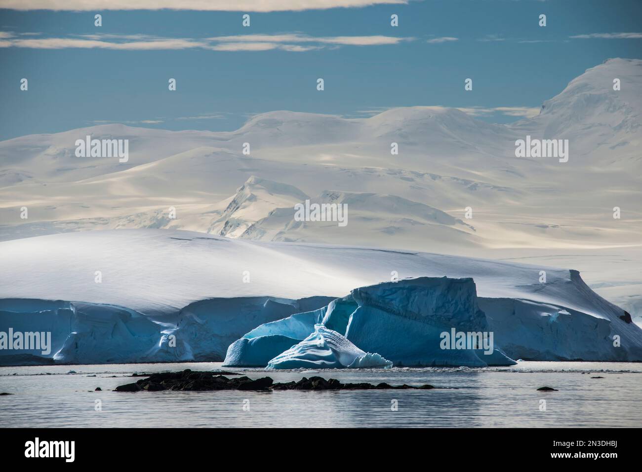 Schneebedeckte Berge ragen über einem Eisberg vor der Enterprise Island in der Antarktis; Antarktis Stockfoto