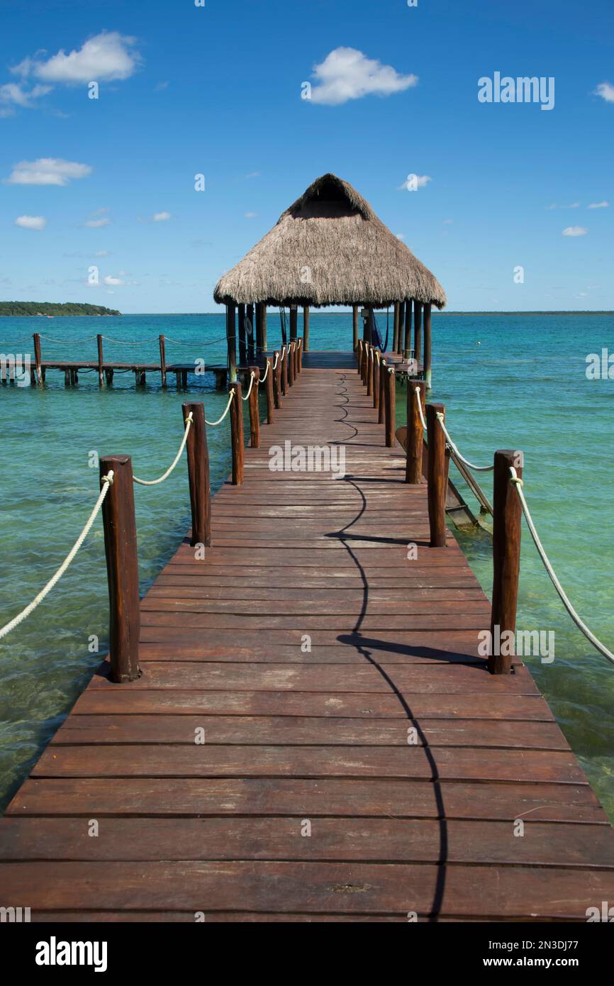 Tiki Hut Pavillon am Dock mit türkisfarbenem Wasser im Rancho Encantado Eco-Resort & Spa in Bacalar; Quintana Roo, Mexiko Stockfoto