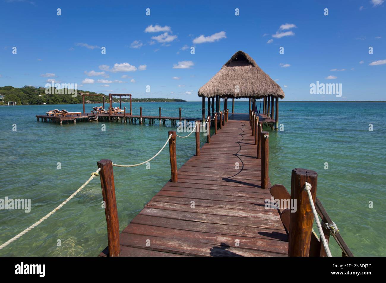 Tiki Hut Pavillon am Dock mit türkisfarbenem Wasser im Rancho Encantado Eco-Resort & Spa in Bacalar; Quintana Roo, Mexiko Stockfoto