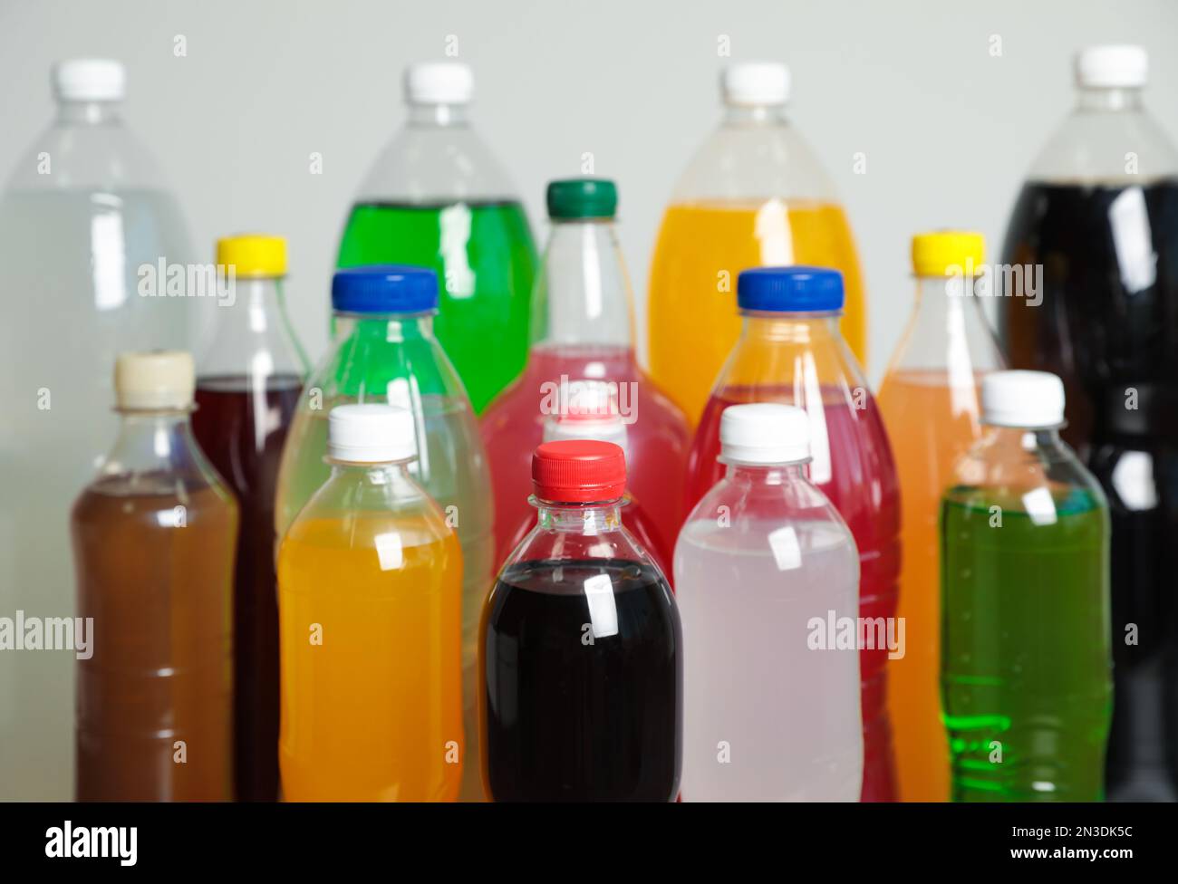 Flaschen mit alkoholfreien Getränken auf grauem Hintergrund Stockfoto
