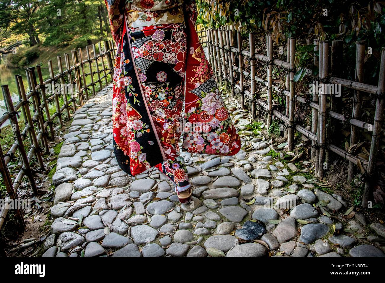 Frau in traditioneller japanischer Kleidung spaziert im Ritsurin Garden, einem großen historischen Garten in Takamatsu; Takamatsu, Shikoku, Japan Stockfoto