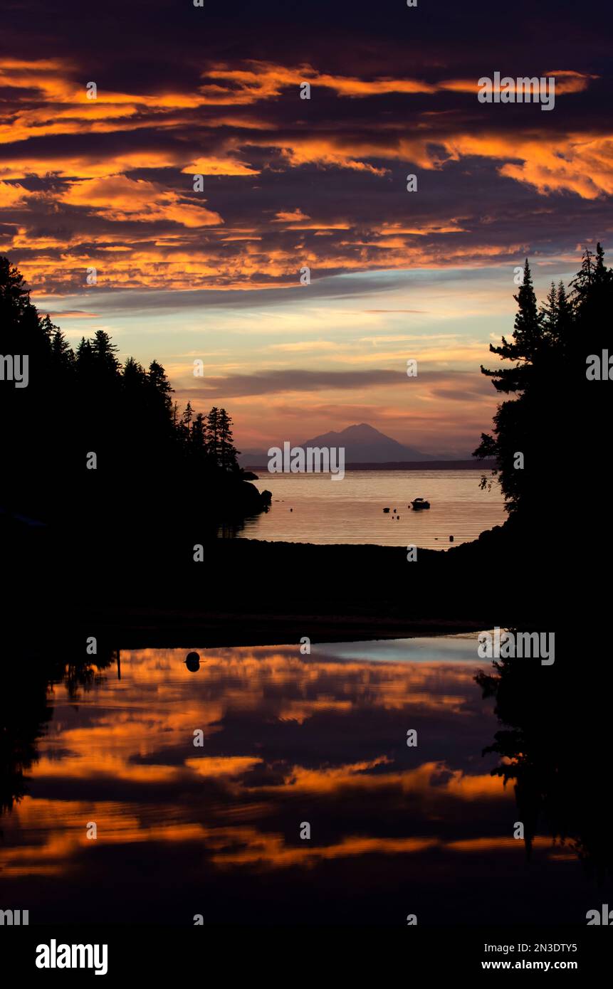 Sonnenuntergang mit Reflexionen und Wolken, Blick westlich von Little Tutka Bay in Kachemak Bay, mit Mount Redoubt im Hintergrund Stockfoto