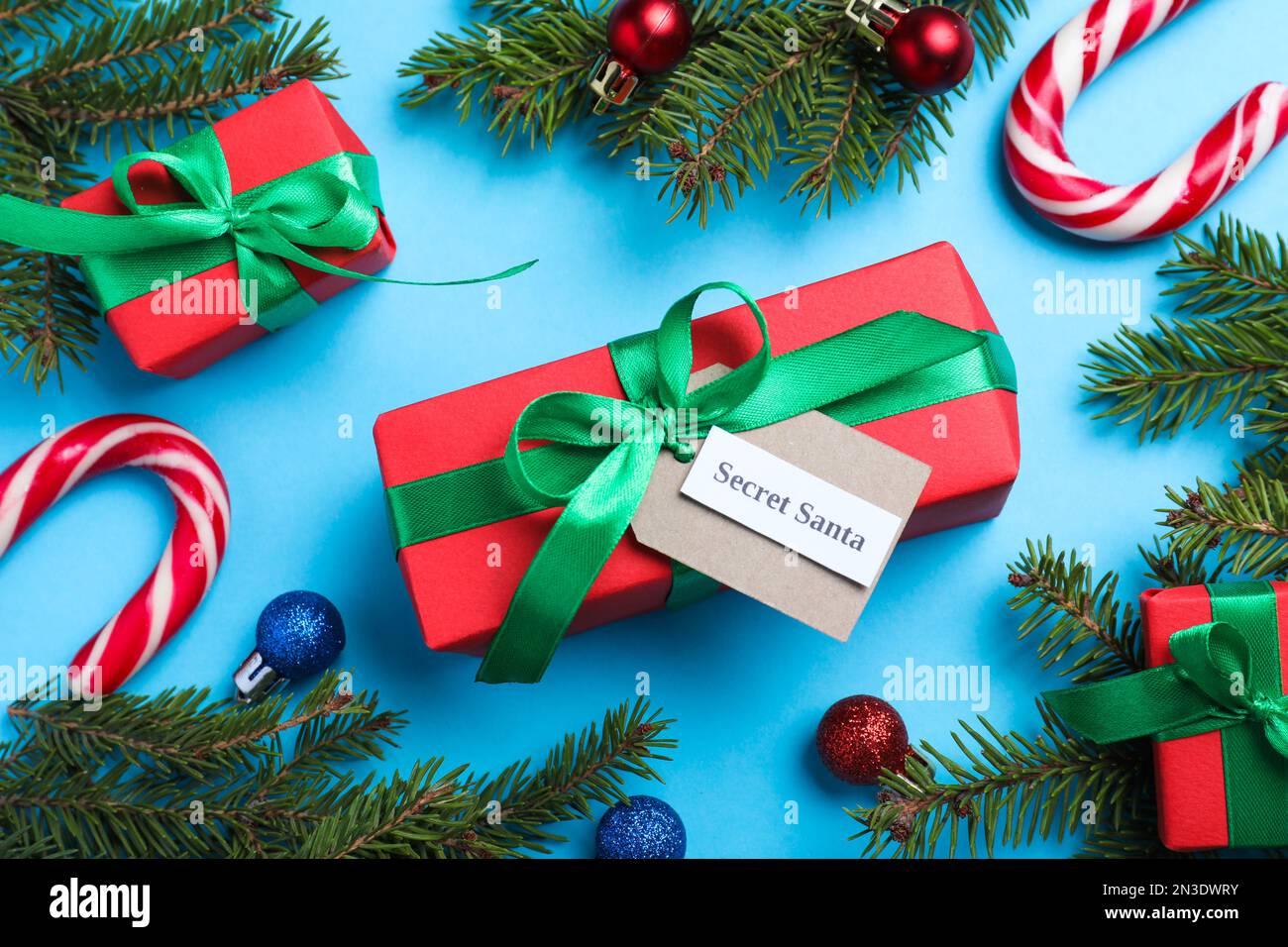 Flach liegend mit Geschenken vom geheimen Weihnachtsmann auf hellblauem Hintergrund Stockfoto