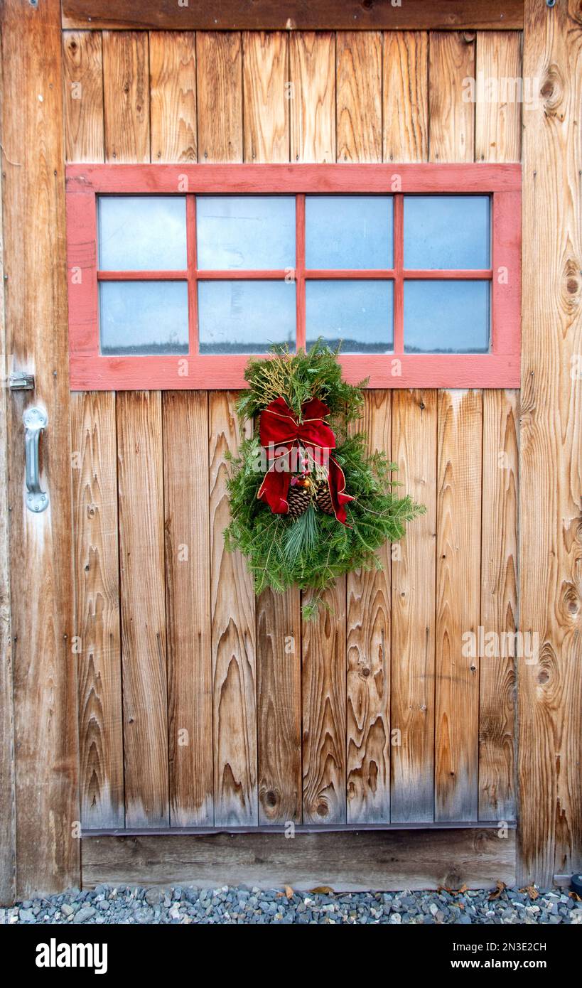 Ein hausgemachter Holiday Swag hängt an einer Scheunentür; Homer, Alaska, Vereinigte Staaten von Amerika Stockfoto