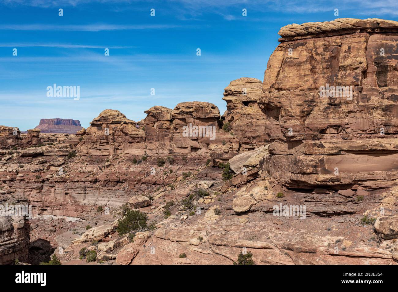 Gestapelte Felsen und großartige Geologie im Big Spring Canyon im Canyonlands National Park mit Islands in the Sky im Hintergrund Stockfoto