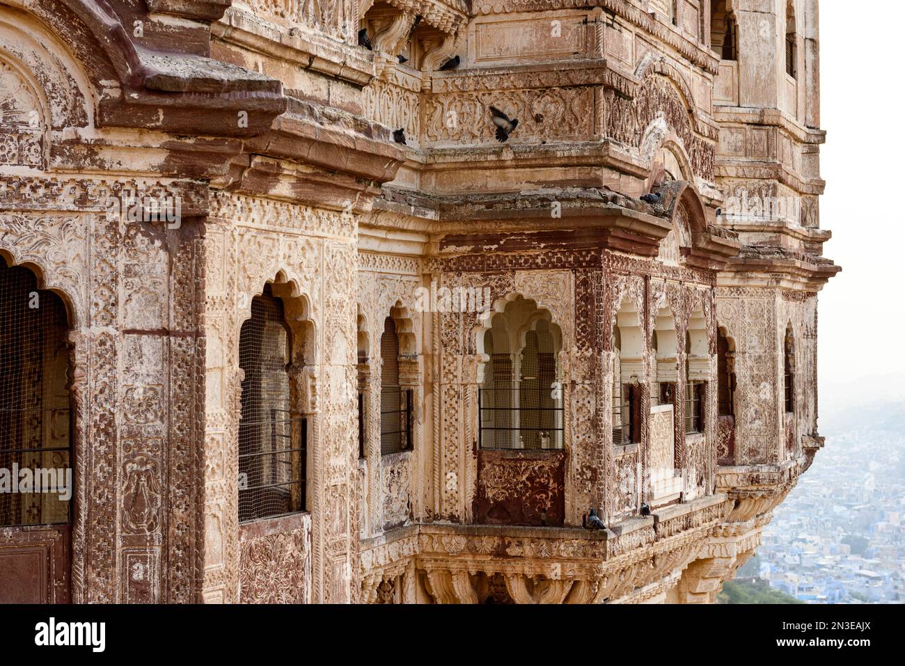 Nahaufnahme des detaillierten Mauerwerks von Mehrangarh Fort mit Blick auf die Stadt Jodhphur darunter; Jodhpur, Rajasthan, Indien Stockfoto