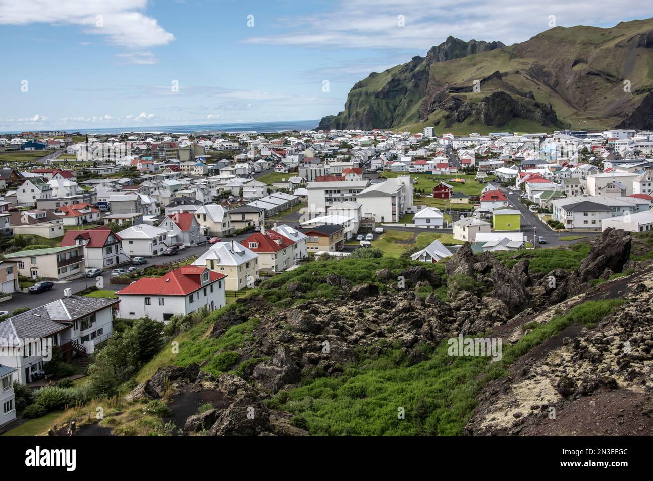 Lava überblickt die Häuser der Stadt auf Heimaey Island, einem Teil der Westman Islands, einem Archipel von etwa 15 Inseln an der Südküste. Stockfoto