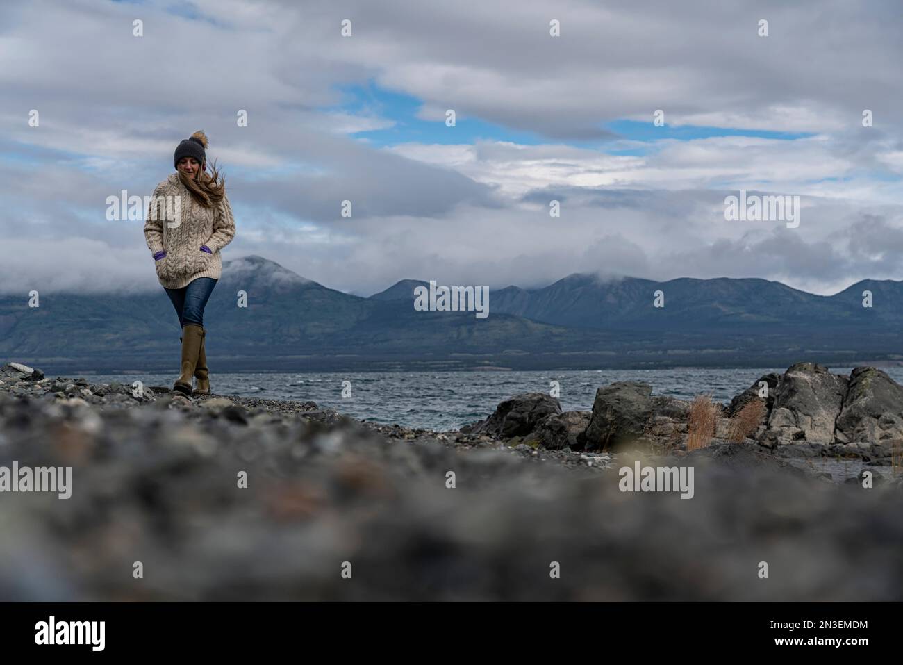 Frau, die am felsigen Ufer des Kluane Lake entlang läuft; Yukon, Kanada Stockfoto