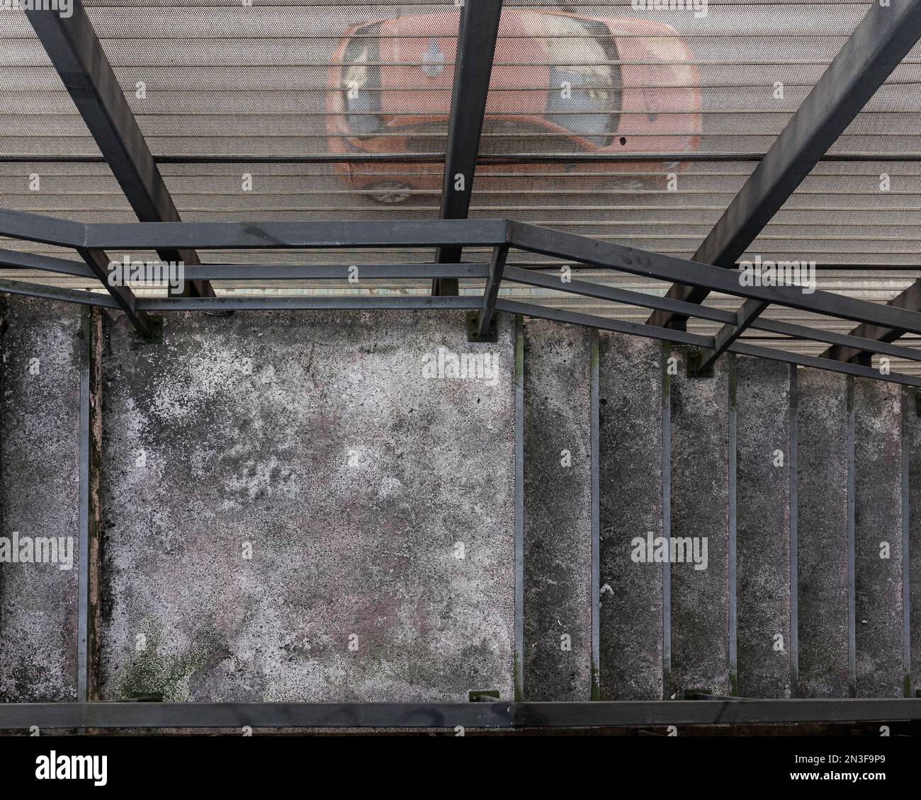 Von der Treppe aus sehen wir durch die eisernen Netzautos, die auf der Straße runterrasen Stockfoto