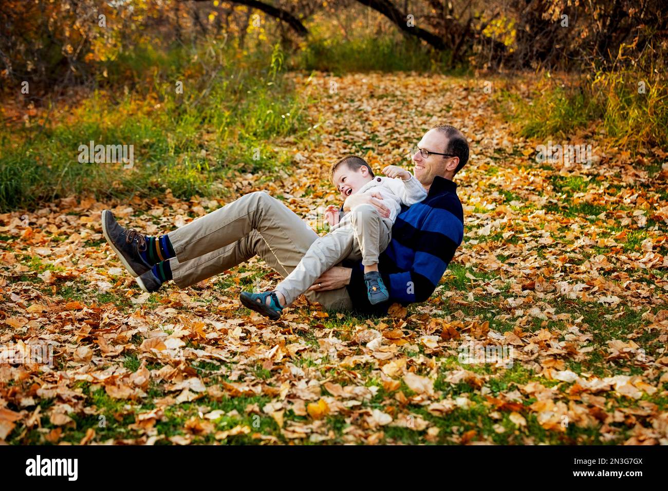 Ein Vater spielt mit seinem Sohn während eines Familienausflugs in einem Stadtpark während der Herbstsaison; St. Albert, Alberta, Kanada Stockfoto