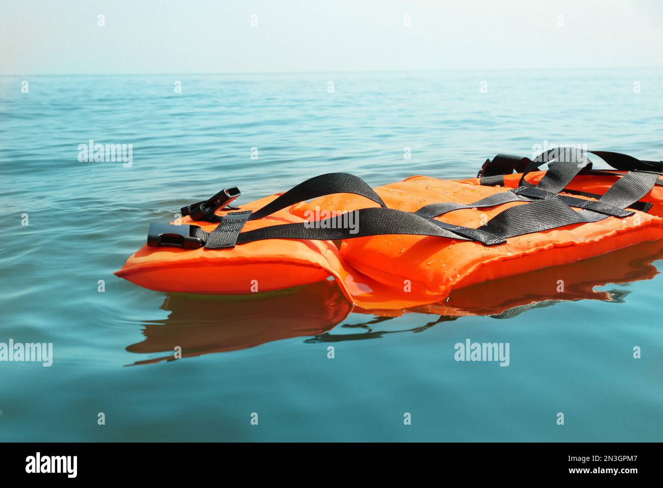 Orangefarbene Schwimmweste, die im Meer schwimmt. Rettungsausrüstung Stockfoto