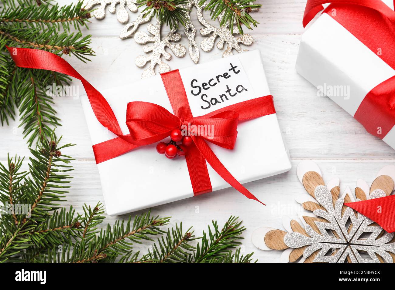 Flach liegend mit Geschenken vom geheimen Weihnachtsmann auf weißem Holztisch Stockfoto