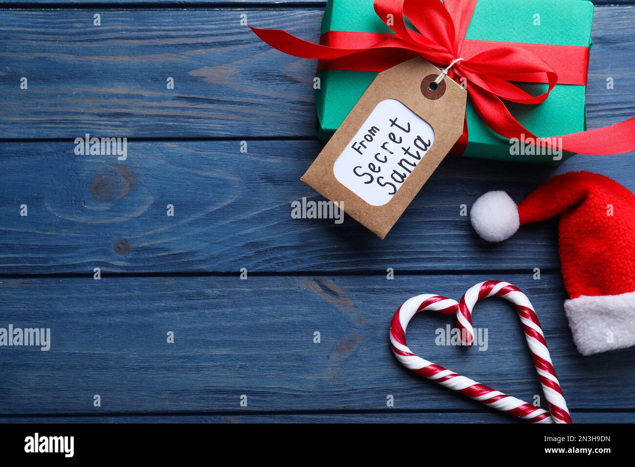 Flach liegend mit Geschenk vom geheimen Weihnachtsmann auf blauem Holzhintergrund, Platz für Text Stockfoto