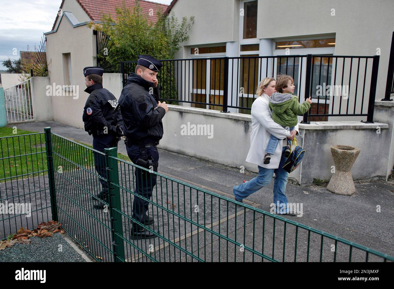 Police officers stand next to a school in Montevrain, east of Paris, Friday Nov. 14, 2014. Scores of police patrolled a small town west of the French capital on Thursday night after a tiger eluded a massive search and remained on the prowl in the region near Disneyland Paris. (AP Photo/Thibault Camus) Stockfoto