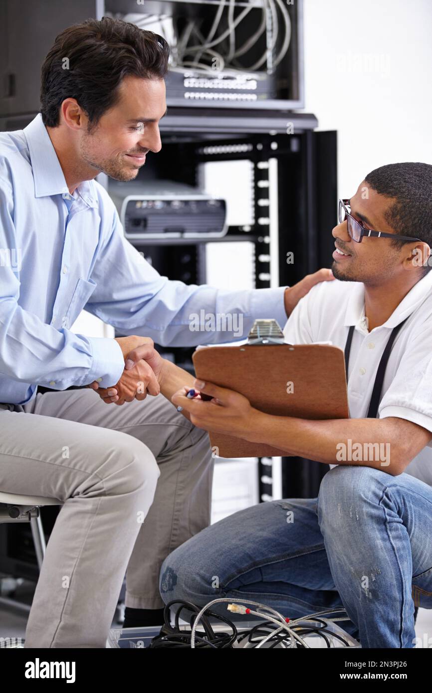 IT-Lösungen mit einem Lächeln. Ein junger IT-Spezialist, der bereit ist, einen Server zu reparieren. Stockfoto