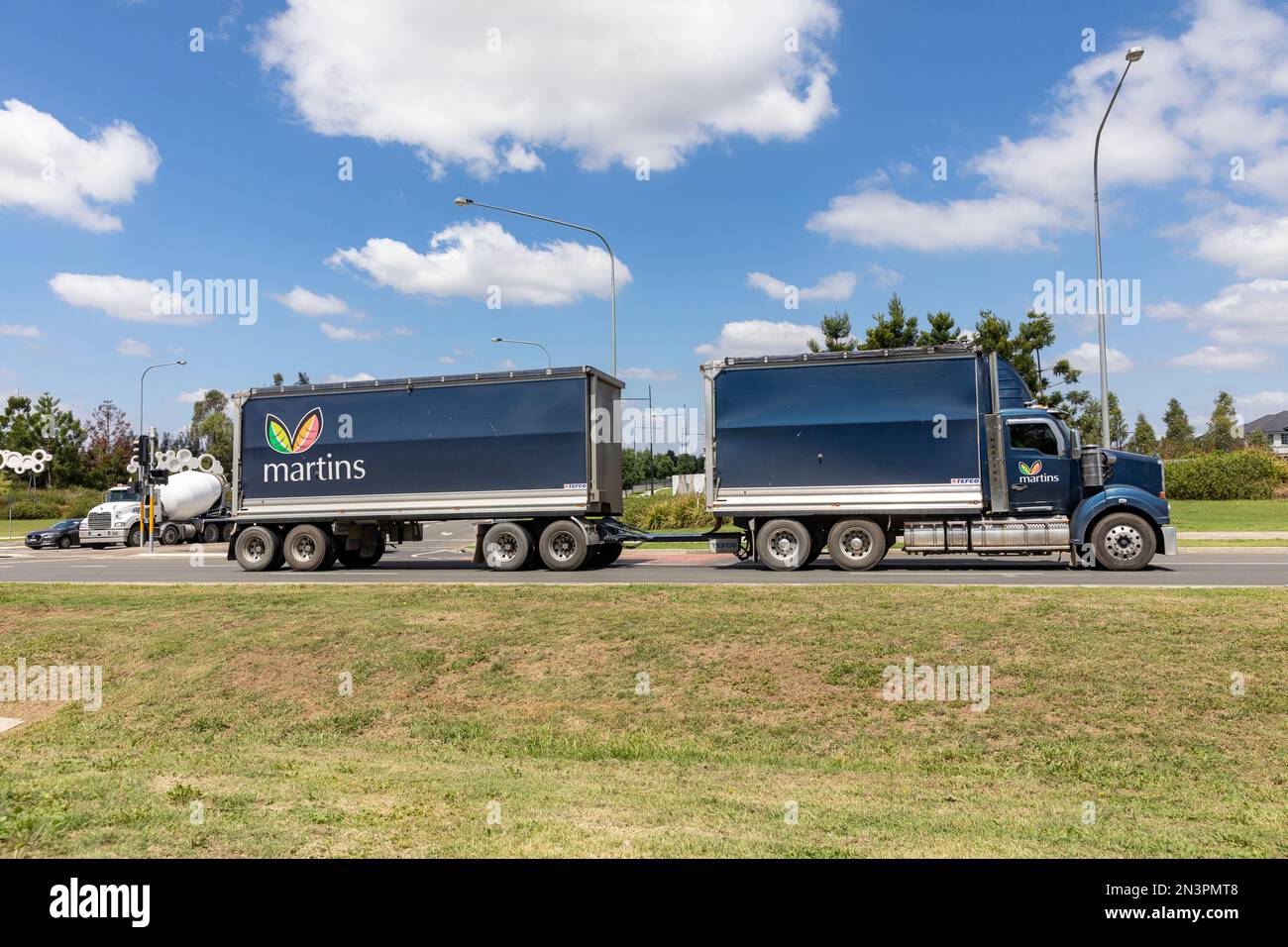 Knickgelenkter Lastkraftwagen für schwere Nutzfahrzeuge, der in New South Wales, Australien, auf der Straße unterwegs ist Stockfoto