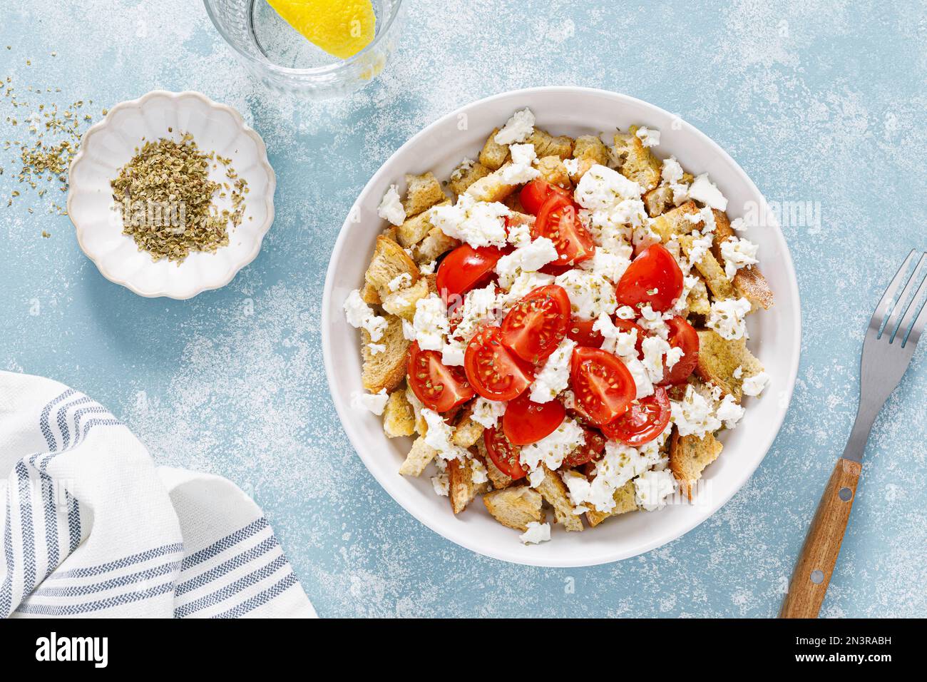 Dakos oder Koukouvagia-Salat. Klassisches Rezept: Kretischer Gerstensalat mit frischen Tomaten, Mizithra-Käse und Oregano. Traditionelles mediterranes griechisches Cu Stockfoto
