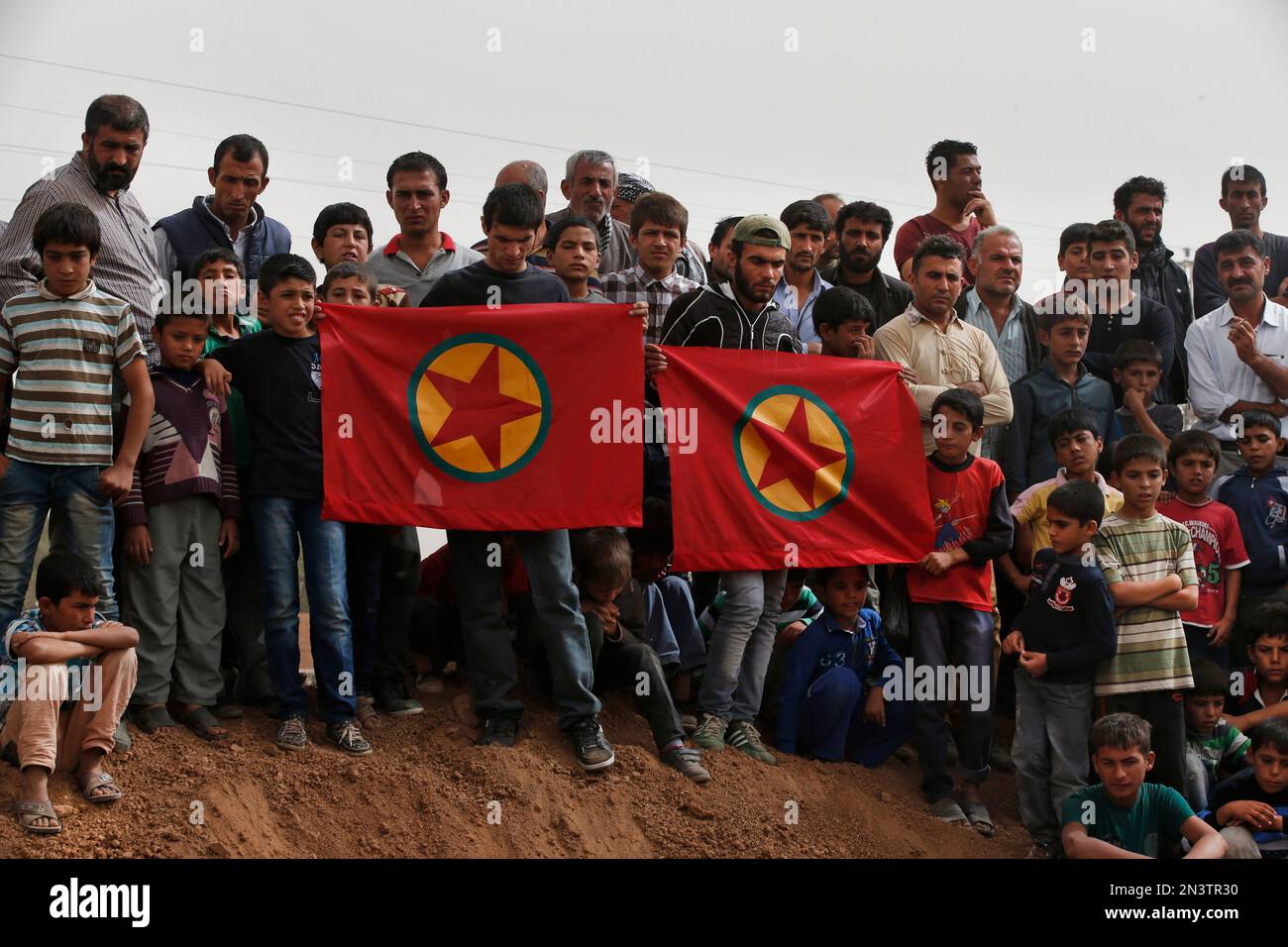 Mourners gather for the funeral of two Syrian Kurdish fighters killed in fighting with militants of the Islamic State group in Kobani, Syria, at a cemetery in Suruc, on the Turkey-Syria border, Saturday, Oct. 11, 2014. Kobani, also known as Ayn Arab, and its surrounding areas, has been under assault by extremists of the Islamic State group since mid-September and is being defended by Kurdish fighters. (AP Photo/Lefteris Pitarakis) Stockfoto