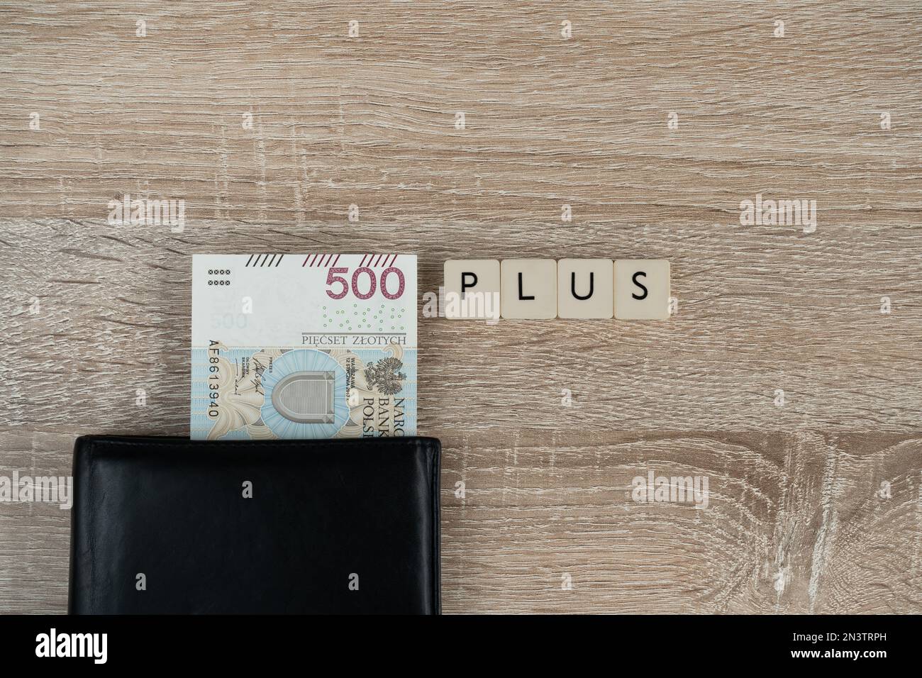 500 polnische Zloty-Banknote in einem Geldbeutel und Wort plus. Family 500+-Programm in Polen. Staatliche Hilfe für Kinder, soziale Hilfe bei der Kindererziehung. Stockfoto