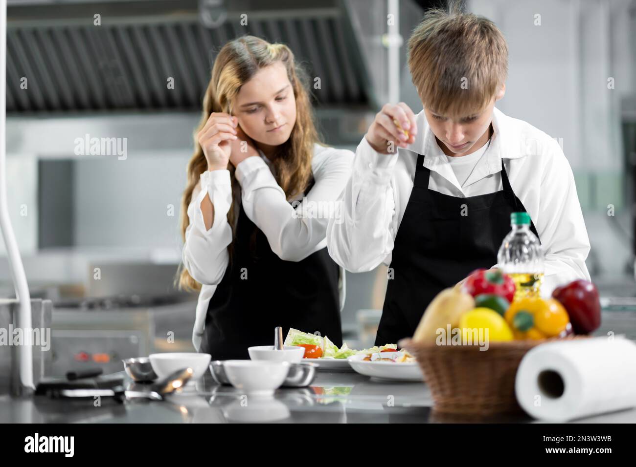 Die Schüler lernen Kochen in einem kulinarischen Institut mit Standardküche und kompletter Ausstattung. Und einen professionellen Koch als Trainer. Stockfoto